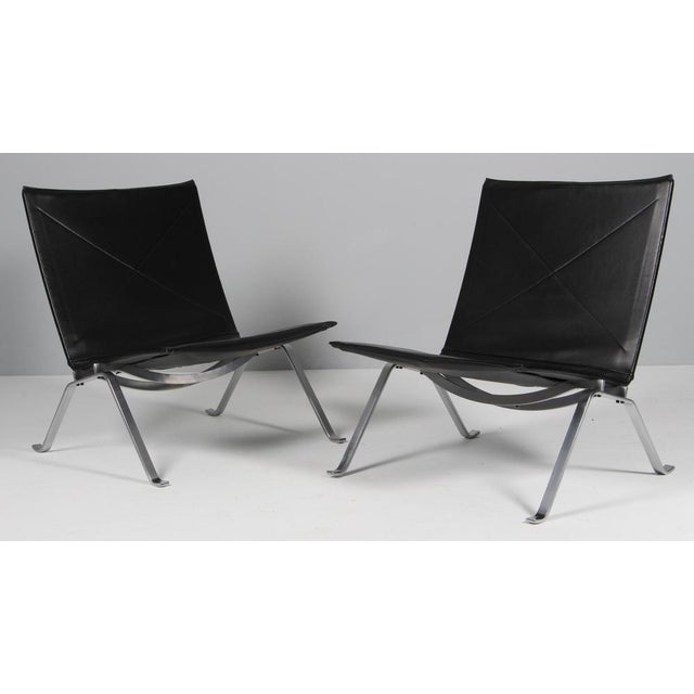 Poul Kjærholm pair of lounge chairs in original black leather. Frame of brushed steel. Model PK22, made by Fritz Hansen....