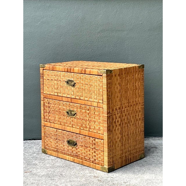 This vintage woven rattan chest of drawers is a beautifully preserved example of mid-century craftsmanship, blending...