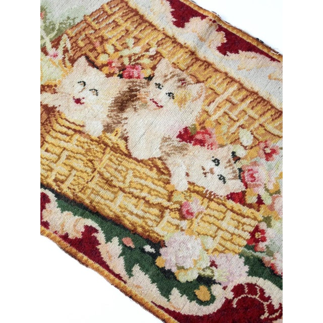 This 19th-century woven tapestry features a charming decorative scene of kittens nestled together in a basket. The...