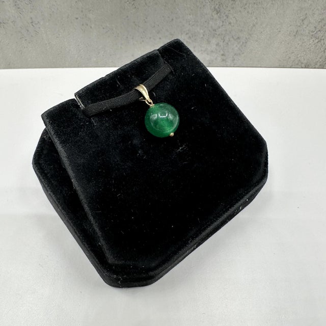 This elegant malachite pendant in 14kt yellow gold features a rich 10mm round malachite stone showcasing its signature...