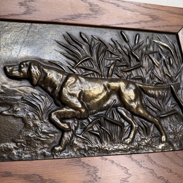 Elegant set of two antique bas-reliefs depicting hunting dogs, executed in dark-patinated bronze and framed in warm wooden...