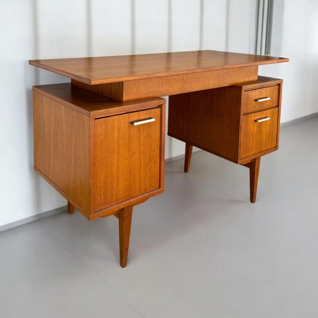 This is a mid-century Danish modern teak writing desk. It has both drawers and open space. It features the iconic floating...