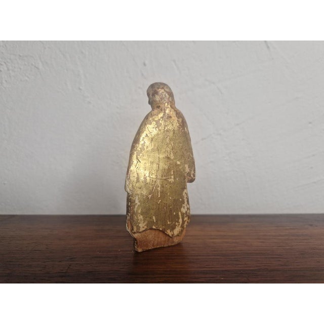 Small baroque figure of a saint, made of wood, covered with gold leaf. The figure is in its unrestored original condition...