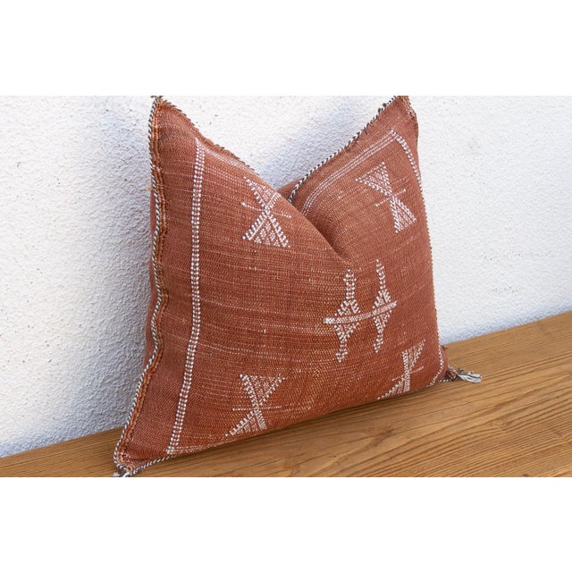 A cascading diamond motif runs the length of this handcrafted Moroccan cactus silk pillow, paired with star-marked...