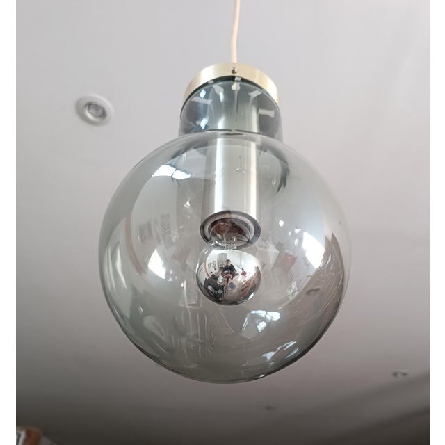 Beautiful Bulb pendant lamp by Raak. Amsterdam, Netherlands, 1970s. Metal frame supporting a stunning blown-glass globe in...