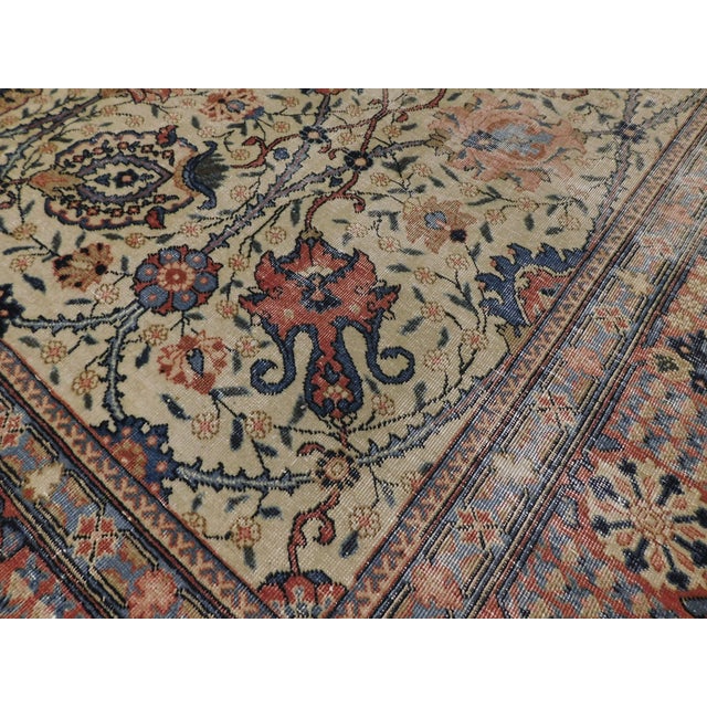 An all-over floral pattern on beige background interconnected by scrolling lines. Wool pile on cotton foundation. A rare...