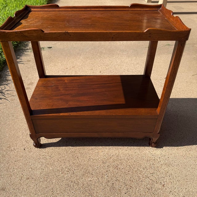 A beautifully crafted vintage Milling Road by Baker Furniture console table featuring an elegant gallery tray top, a...