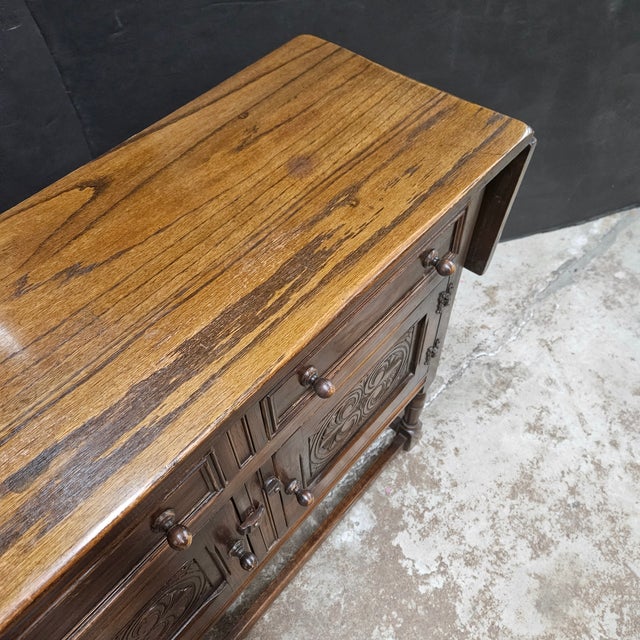 This English Oak Sideboard With Carved Cabinet Doors and Drop Ends is great for storage and for serving. It has 2 drawers...