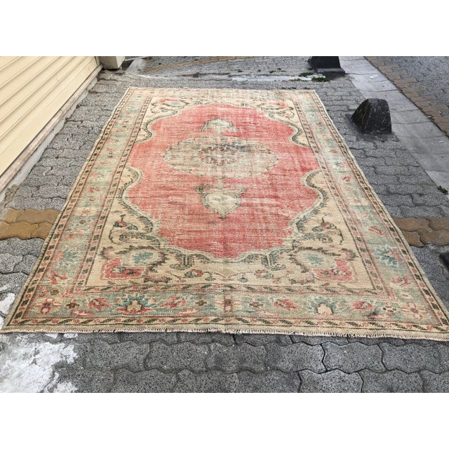 This is a vintage Turkish Oushak rug from the 1960s. The piece was hand-knotted.