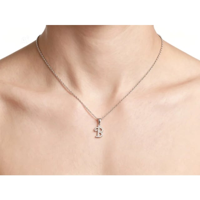 This modern 18K white gold pendant necklace features a "B" initial slide accented with brilliant diamonds totaling 0.4...
