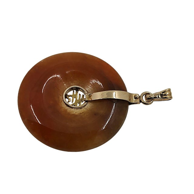 14K gold orange jade disc pendant. This circle pendant is a beautifully carved orange jade disc held in a 14 karat yellow...