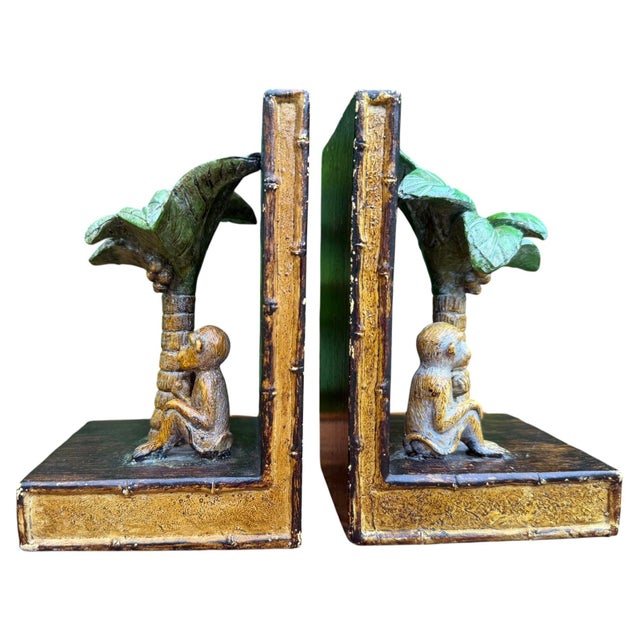 A charming pair of vintage hand-painted bookends featuring sculptural monkeys seated beneath lush palm trees. Rich faux...
