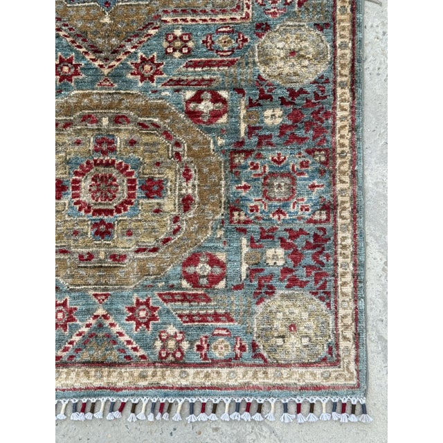 A hand-knotted runner in the Mamluk design, woven in Afghanistan on a soft teal ground with olive-gold medallions, crimson...