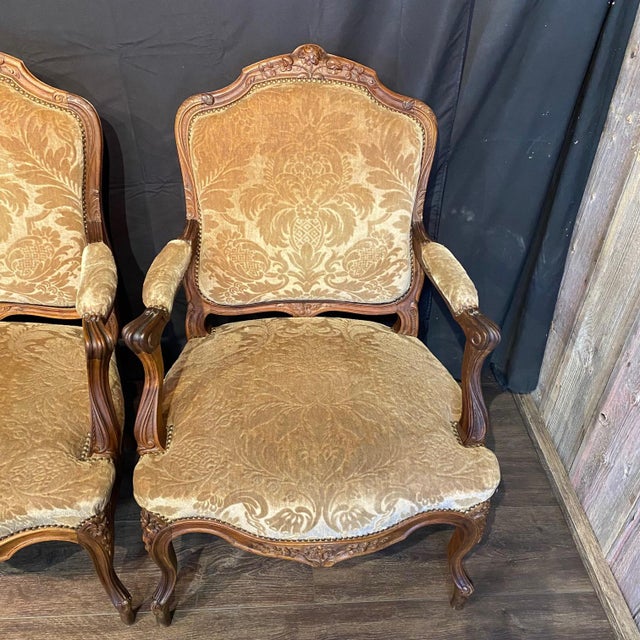 Elegant set of four French Louis XV armchairs with gracefully carved wood frames and luxurious gold beige cut velvet...