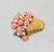 1980s goldtone molded pink resin flowers with faux-pearl centers and accents in a basket brooch with a security clasp....