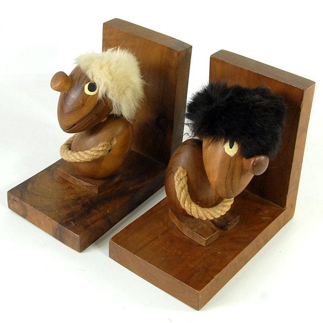 A pair of decorative teak bookends, "The Optimist and the Pessimist," designed by Hans Bolling, originated in Denmark in...