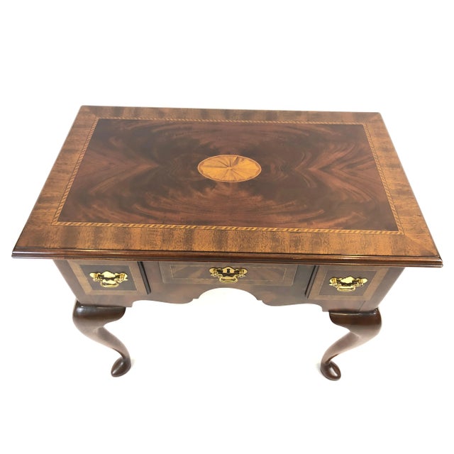 A handsome traditional style flame mahogany inlaid low boy or small console with 3 drawers having lovely satinwood fan...