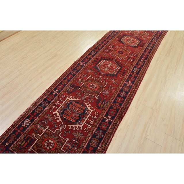 An authentic semi-antique tribal Karajeh runner hand-knotted with fine wool and natural dyes. This nomadic oriental rug...