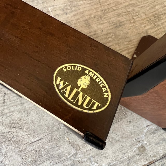 These vintage bookends, crafted from solid American walnut, feature elegant black accents and protective red felt bottoms....