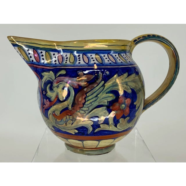 Beautiful traditional Italian majolica luster glaze pitcher decorated with winged dragons .