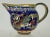 Beautiful traditional Italian majolica luster glaze pitcher decorated with winged dragons .