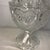 This vintage pressed clear crystal glass footed candy dish features a repeating heart and rose pattern with a matching...