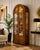 Exceptional vintage display cabinet confidently attributed to Mastercraft, featuring a dramatic arched silhouette clad in...