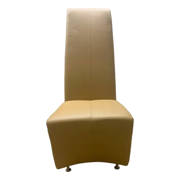 The Elika dining chair by Brueton in tan leather features a tall, slender, and sleek silhouette. Its refined design is...