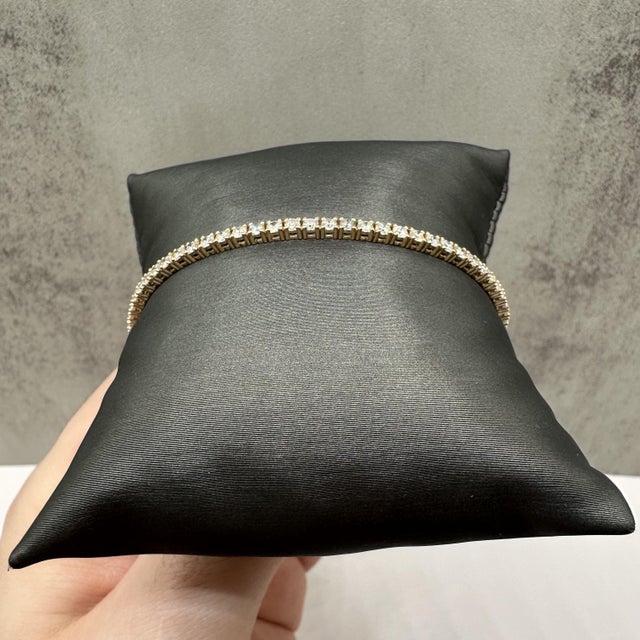 This stunning natural diamond tennis bracelet in 14kt yellow gold features 3.1 carats total weight of GH SI2–I1 round...