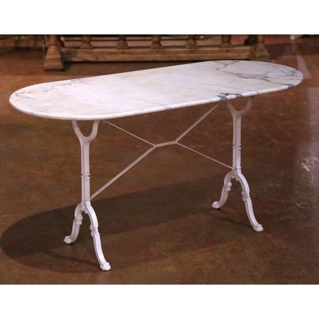 Crafted in France circa 1920, this elegant antique pastry table features a graceful oval Carrara marble top resting on a...