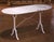 Crafted in France circa 1920, this elegant antique pastry table features a graceful oval Carrara marble top resting on a...