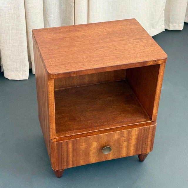 This petite single end table nightstand circa the early 1940s blurs the lines between Art Deco and Mid Century Modern. The...