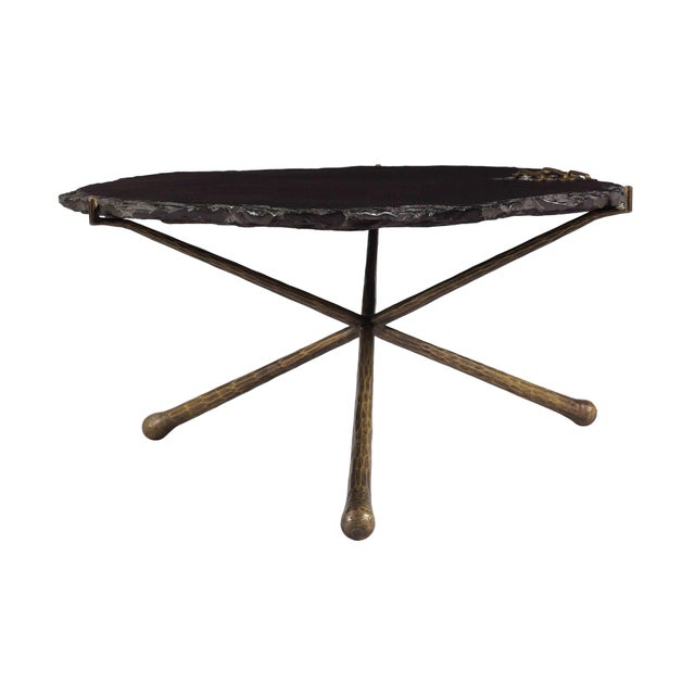 Stunning craftsmanship is displayed with the Serra cocktail table. A solid slab of black stone rests upon an antique brass...