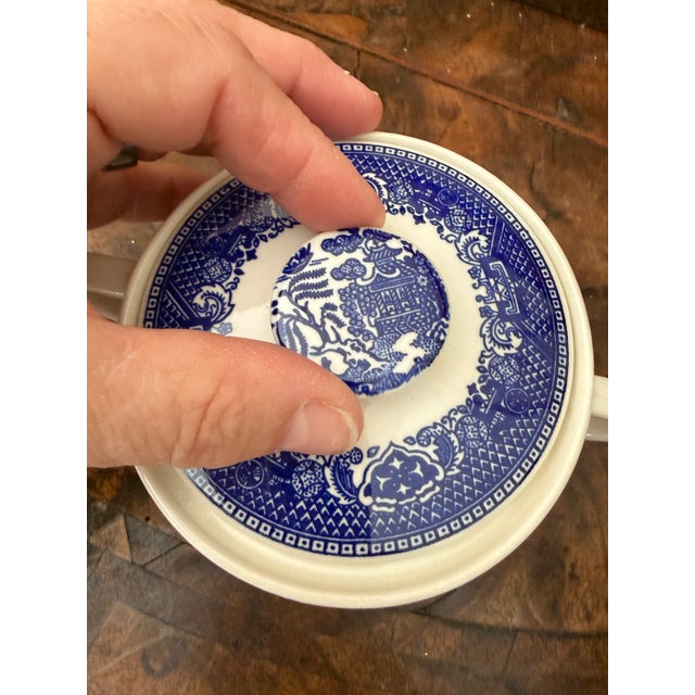 Classic blue willow transferware sugar bowl with lid and matching creamer, featuring the timeless chinoiserie landscape...