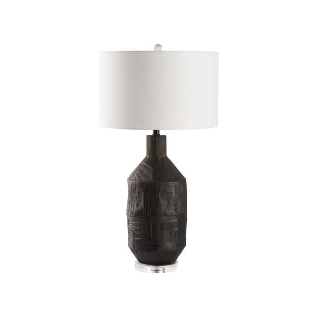 This ceramic lamp showcases a matte black finish accented by subtle lines and textures, creating a soft, understated...