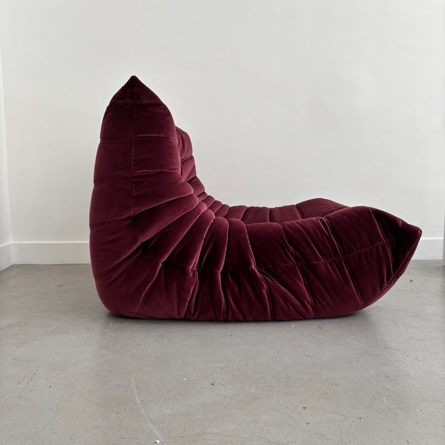 Reupholstered armchair in pinkish-purple velvet. The armchair will be delivered with its original cover. This piece has an...