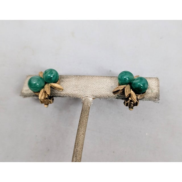 1960s goldtone leaves with two cabochon faux-jade clip earrings. Marked "PANETTA" on the clips. Measure: 3/4 inches long...