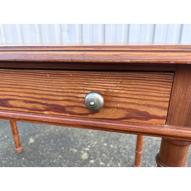 Elegant antique desk in pitch pine, a wood renowned for its robustness and deep grain. This piece features beautiful...