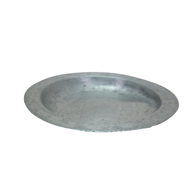 Antique 18th century primitive pewter charger plate featuring a beautiful worn patina. Dimensions: 11.5" x 1" (D x H)