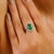 This elegant ring features a 2.26-carat oval-cut Zambian emerald, surrounded by a halo of brilliant round-cut diamonds...