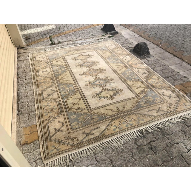 This is a vintage Turkish Oushak rug from the 1960s. The piece was hand-knotted.