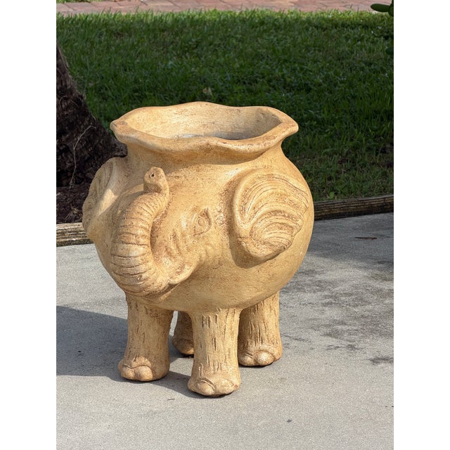 A wonderfully sculptural elephant planter featuring a rounded body, expressive curved trunk, oversized ears, and four...