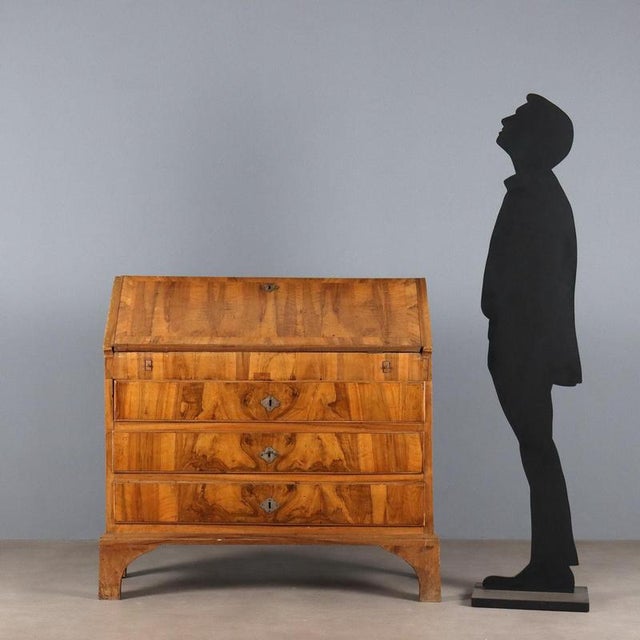 Walnut and burr walnut drop-leaf chest. Three drawers front surmounted by a drop-leaf door, supported by pull-out drawers,...