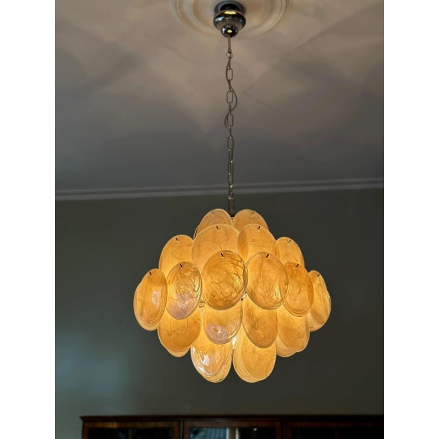 Eclectic bold amber colored italian murano chandelier in 1970's style. The chandelier has 36 glass discs in vistosi style...