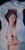 In "Where is Home?", the figure lies enveloped in a billowing white fabric, creating a stark contrast against the deep...