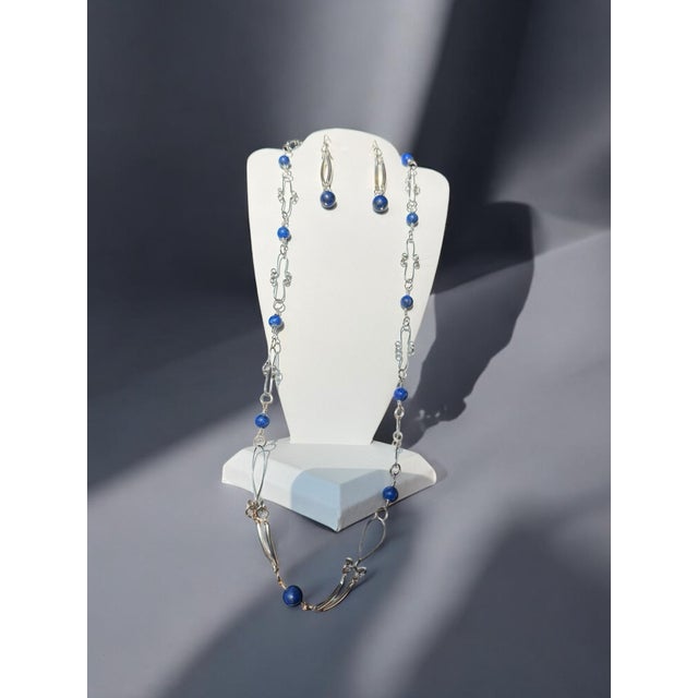 Beautiful lapis lazuli beads artfully wired with curved bars. Dangle earrings marked 925 on a lever back hinged clasp....