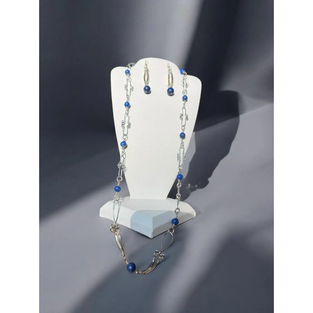 Beautiful lapis lazuli beads artfully wired with curved bars. Dangle earrings marked 925 on a lever back hinged clasp....