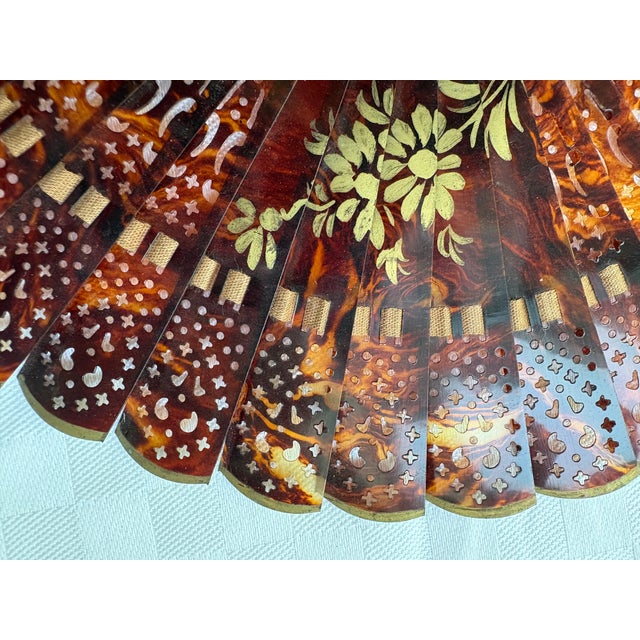 This is a very rare petite sized hand painted tortoise shell fan. The fan has been hand painted with a center flower that...