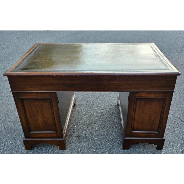 A handsome English Georgian mahogany partners’ desk, dating to the early 19th century, with a richly figured mahogany...