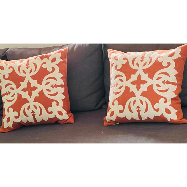 Pair of burnt orange wool pillows with figurative white appliqué and feather down insert.